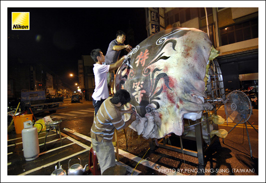 七月十九日深夜子時過後，才可宰殺獻祭豬羊。現代神豬幾乎都重如一輛小汽車，必須由專業團隊（通常由飼養者召集組成）處理及裝飾，其費用包含在議定的豬價當中，惟飼養者不下第一刀，否則將影響未來的養神豬事業。（Nikon D2X，ISO 320，AF-S 12-24mm F4G鏡頭，焦距12mm，f4減0.7級光圈先決，快門1/6秒）
