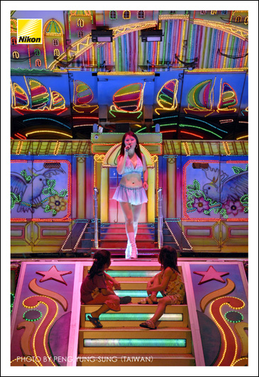 輪值庄頭舉辦社區晚會的大型舞臺，就像「變形金剛」一樣，是由一輛自走貨車展開而成，不但有乾冰、噴火、燈光、音效，就連旋轉、升降舞臺也一應俱全；這也可算是「臺灣奇蹟」之一吧。（Nikon D2X，ISO 320，AF-S 17-55mm F2.8G鏡頭，焦距55mm，f2.8減0.3級光圈先決，快門1/80秒）