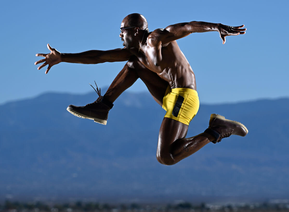 Joe McNally photo of a model in air, with mountains in the background